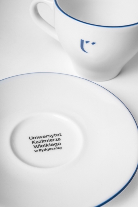 Filiżanka z logo UKW oraz spodek z nazwą Uniwersytetu Kazimierza Wielkiego.