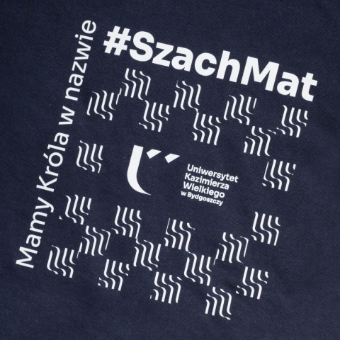 Zbliżenie białego nadruku z hasłem „Mamy Króla w nazwie #SzachMat” i logo UKW.
